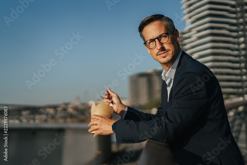 Obraz na plátně Businessman enjoying an outdoor lunch break in a modern city