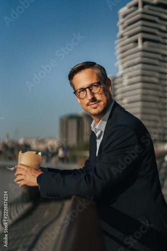 Obraz na plátně Businessman holding takeaway coffee during an urban lunch break