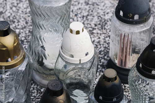Obraz na plátně Glass cemetery memorial candles with plastic lids