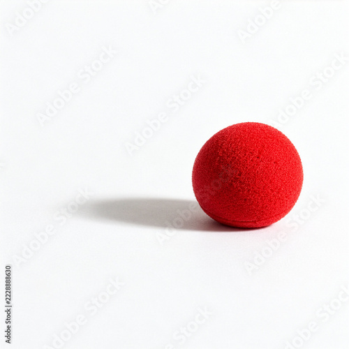 Red Clown Nose on White Background as a Minimal Symbol of Carnival and Costume Fun