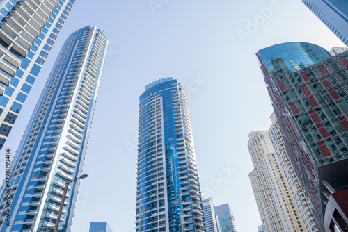 A view of skyscrapers. A business center in a big city, a tall building covered in glass windows.