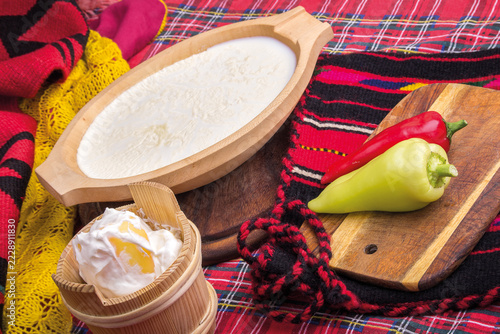 Fresh White Cheese and Cream in Wooden Bowls with Peppers