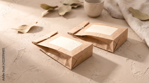 Kraft paper tea packaging with blank labels on a textured tabletop
