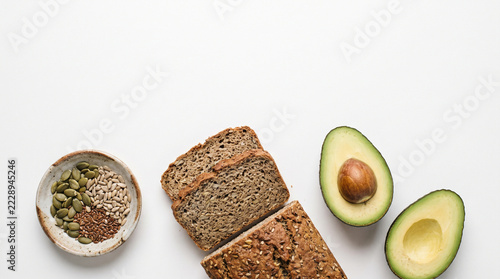 Avocado and seeded bread with mixed seed bowl arranged on white background for healthy food styling and nutrition