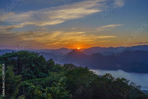 新しい始まりや希望を象徴する山並みに沈む夕日と澄み渡る美しい自然風景
