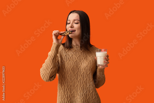 Comfort food and indulgence, young woman eating chocolate chip cookie with gl...