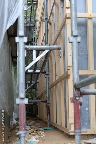 Vertical Shot Looking Up Through Scaffolding at New Wood Siding Installation with Protective Sheet