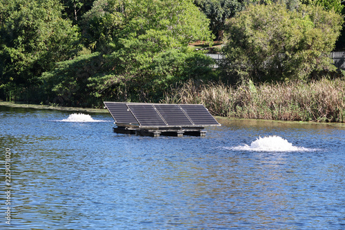 Floating solar powered pond aerator system operating on a lake to improve water quality and circulation