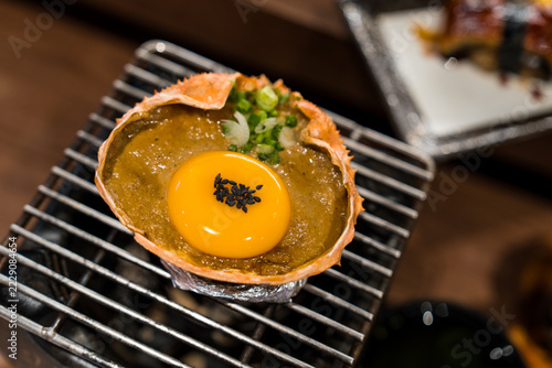 Obraz na plátně Kani Miso, crab miso in shell bowl topped with elevated premium toppings with egg yolk, black sesame, bowl and sliced ​​scallions