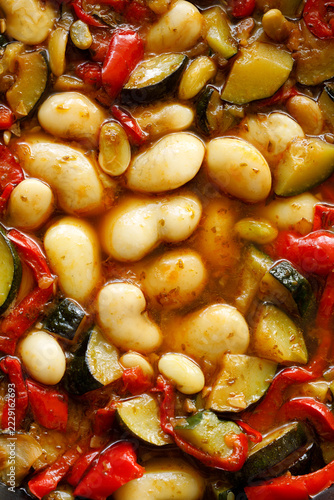Stewed butter beans with zucchini and red peppers, vegetarian stew top view full frame