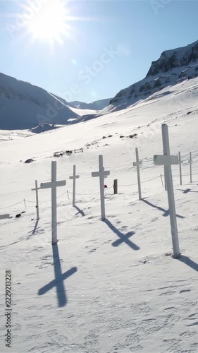 White wooden crosses of the historic cemetery in the snow against arctic mountains in Longyearbyen Svalbard Norway
