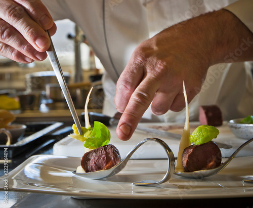 Aperitif spoon featuring an artfully arranged gourmet amuse-bouche: pan-seared beef tenderloin (served medium-rare) with Savoy cabbage and parsnip purée.
