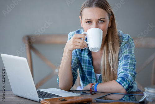 Young Woman Drinking Coffee During a Laptop Work Break