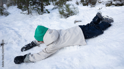 Fotografie Child sliding down snowy hill having fun