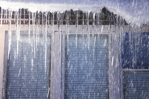 Icicles Hanging from Roof During Snowstorm on Winter Day