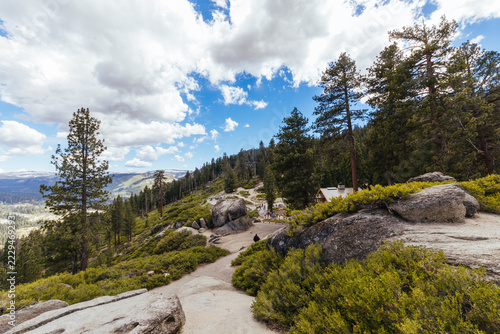 Hikers walking along scenic mountain trail at Glacier Point in Yosemite National Park California