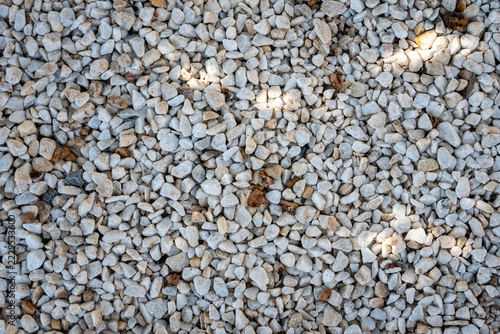 Gravel stones forming a sunlit natural textured background