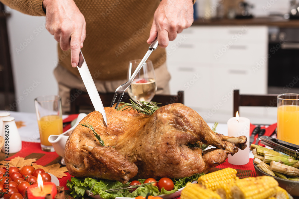 Obraz premium Man carving a golden roasted turkey for Thanksgiving dinner
