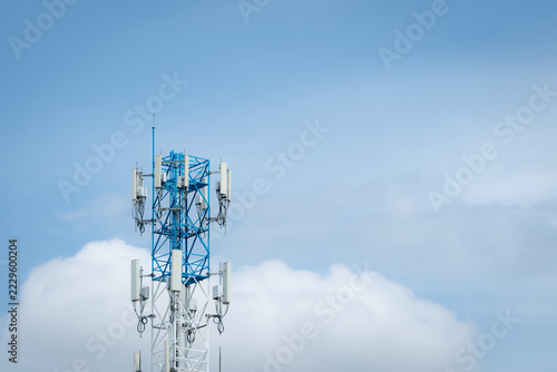 Cellular telecommunication tower with 5G antennas under clear blue sky and clouds, providing high speed wireless network coverage for mobile phones, internet connectivity and digital communication