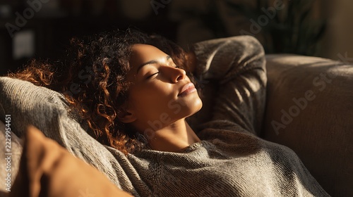relaxed woman resting on sofa at home with eyes closed. mental wellness, stress relief and self care lifestyle concept