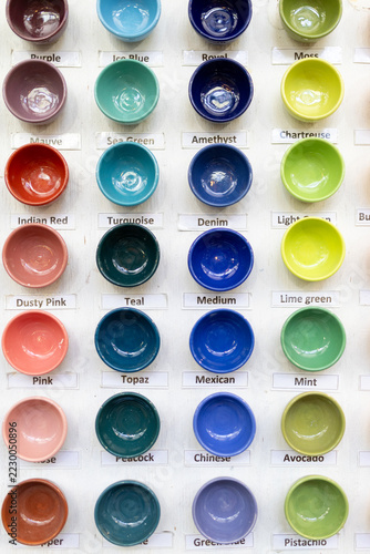 Fotografie Display of colorful ceramic bowls with descriptive color labels