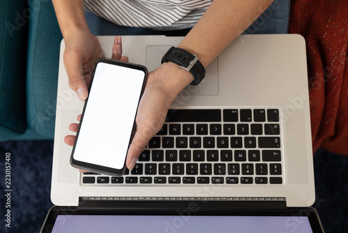 Woman using a smartphone and laptop