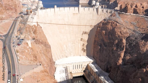 Hoover dam spanning black canyon and holding back lake mead on nevada arizona border, with its concrete wall, hydroelectric infrastructure, and desert landscape under bright sunshine