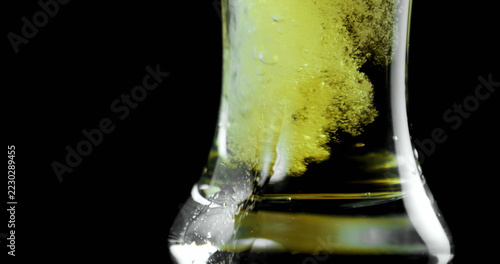 Close-up of beer poured in glass against black background