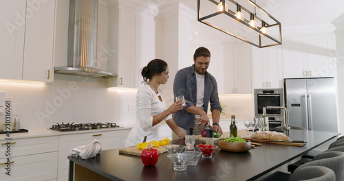 Couple preparing fresh salad together in modern kitchen, enjoying cooking time