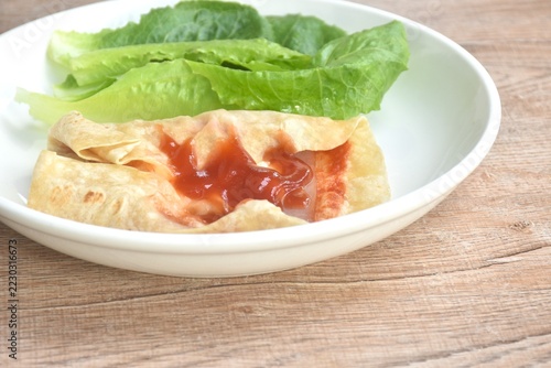 berrito stuffed slice ham pork with cheese dressing ketchup sauce eat couple fresh cos lettuce vegetable salac on plate