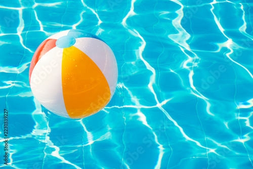 Fotografie Colorful inflatable ball floating in swimming pool
