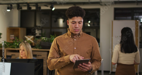 Image of focused man with tablet working late in office