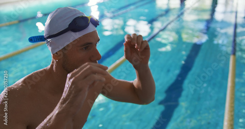 Caucasian swimmer prepares for a race at an indoor pool