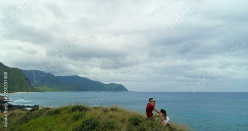 Drone view of caucasian couple sitting in coastline with copy space