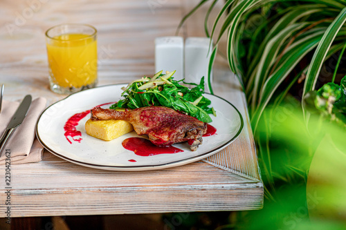 Fotografie Restaurant table setting with plated duck and fruit sauce