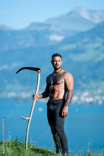 Fotografie Farmer work with manual scythe mowing