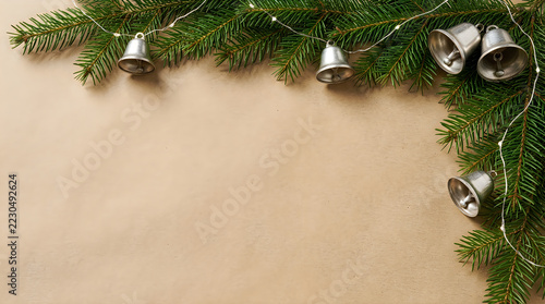 Silver bells hanging on green fir branches holiday decoration