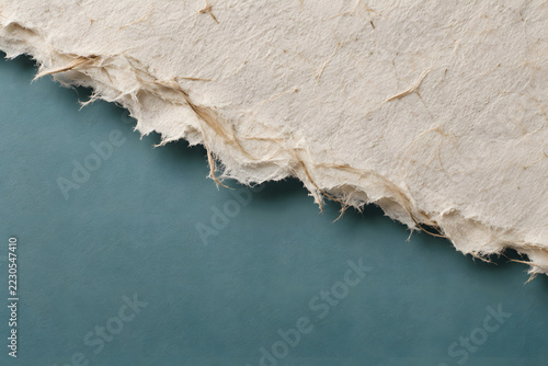 Torn Cream Paper with Fibrous Edge on Teal Background