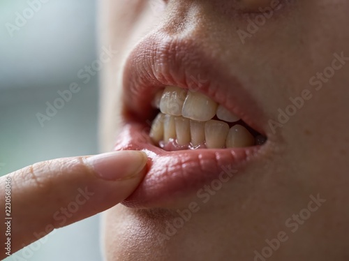 Close-up of person brushing teeth with electric toothbrush in bathroom setting