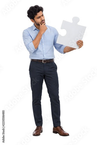 Thoughtful Man Holding A White Puzzle Piece