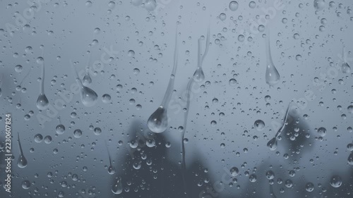 Forming droplets merging into streaks and sliding down window glass rain falling