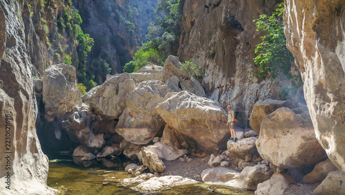 Hiker exploring the towering limestone gorge of Torrent de Pareis in Mallorca, Spain