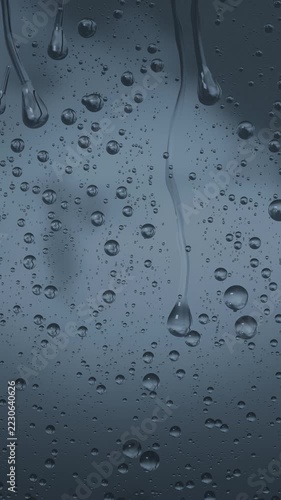 Vertical video: Showing window glass pane forming sliding long drops and vertical streaks from rain