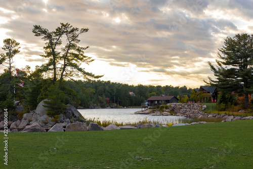 Tranquil sunset view along Killarney Channel, Ontario with lush trees and rocky shoreline.