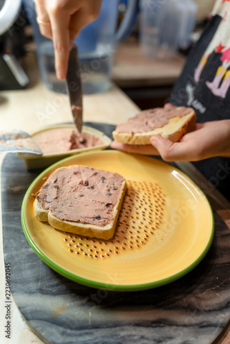 Spreading Savory Pate on Fresh Bread Slices for a Delicious Snack
