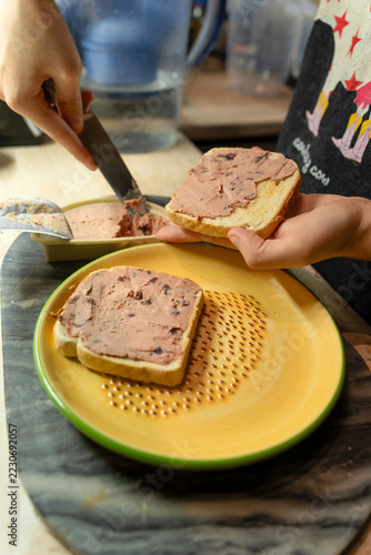 Hands Spreading Savory Liver Pate on Toasted White Bread