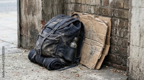 Old Dark Backpack and Folded Cardboard on Grungy Street Corner