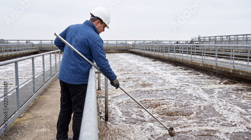 Operator taking sample at aeration basin water treatment plant people staff environment