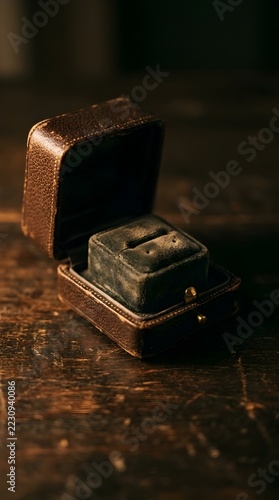 Engraved ring nestled in velvet lined copper jewelry box on dark wood surface