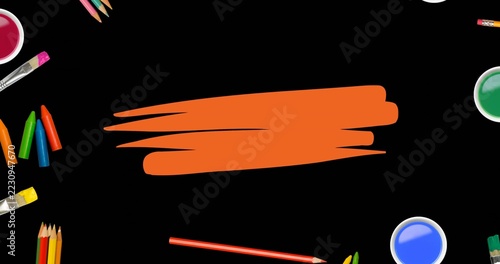 Displaying central orange brushstroke on black flatlay, with pink green blue wells, brushes